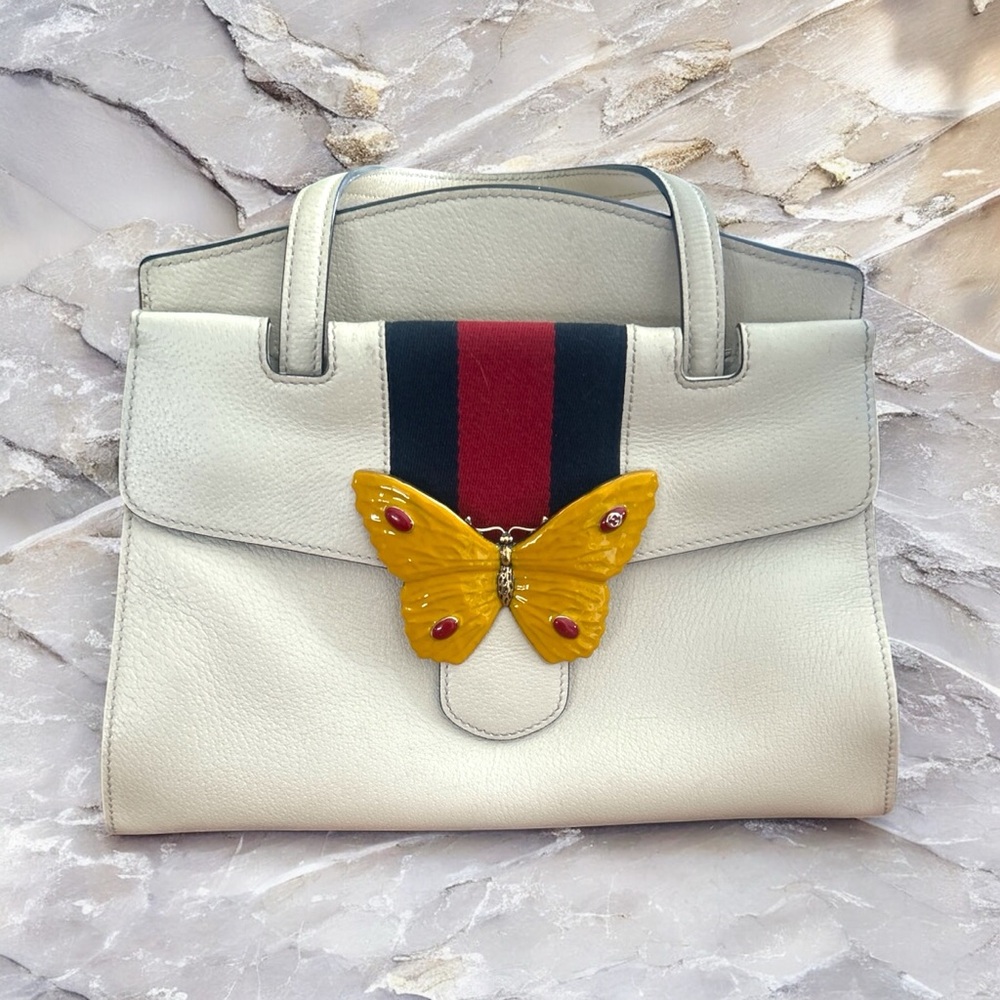 Gucci Elegant Cream Handbag with Butterfly Accent and Gucci Strap